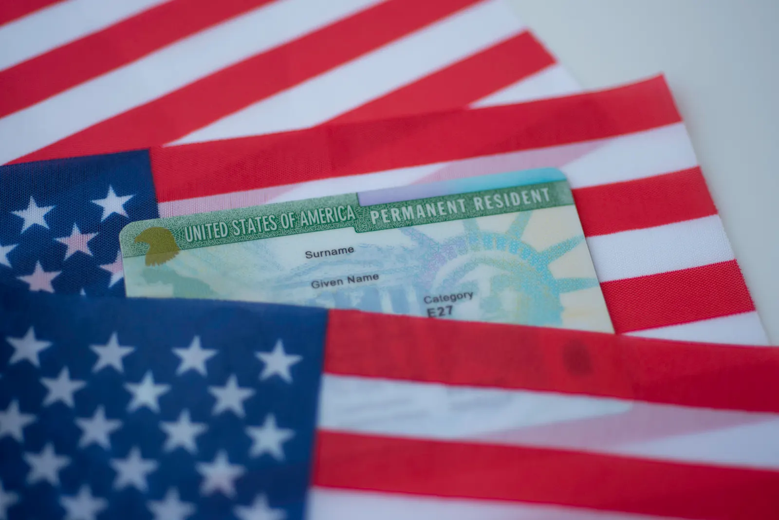 Imagem de três bandeiras dos Estados Unidos pequenas com um documento dos Estados Unidos entre eles.