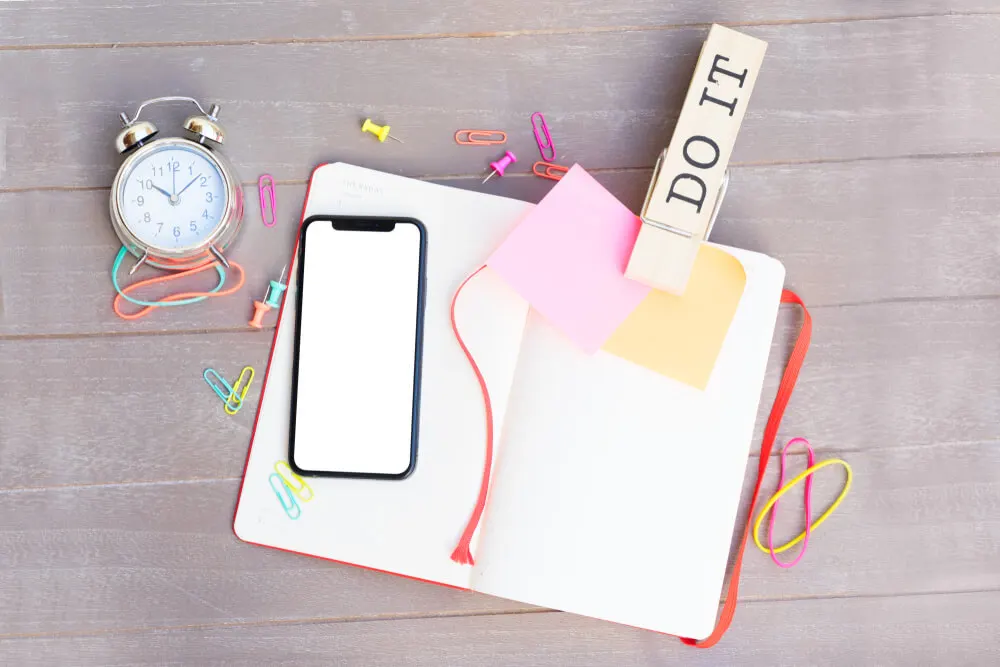 Mesa com planner, celular e despertador